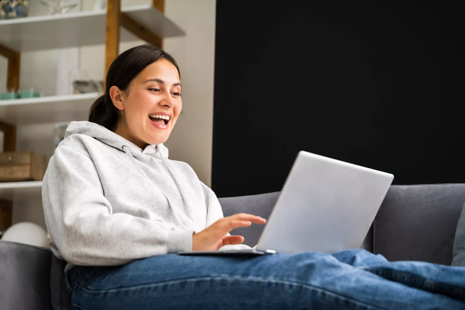 Schülerin mit Laptop auf der Couch sitzend